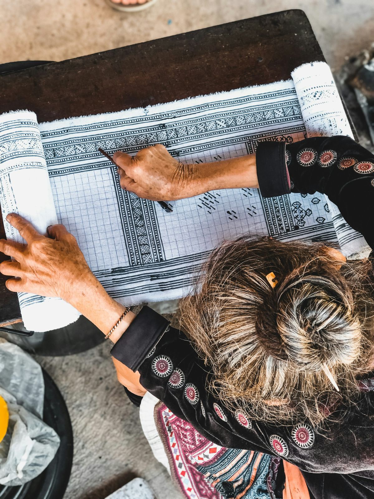 Indian architect with mehendi-adorned hands drafting plans on a drawing board