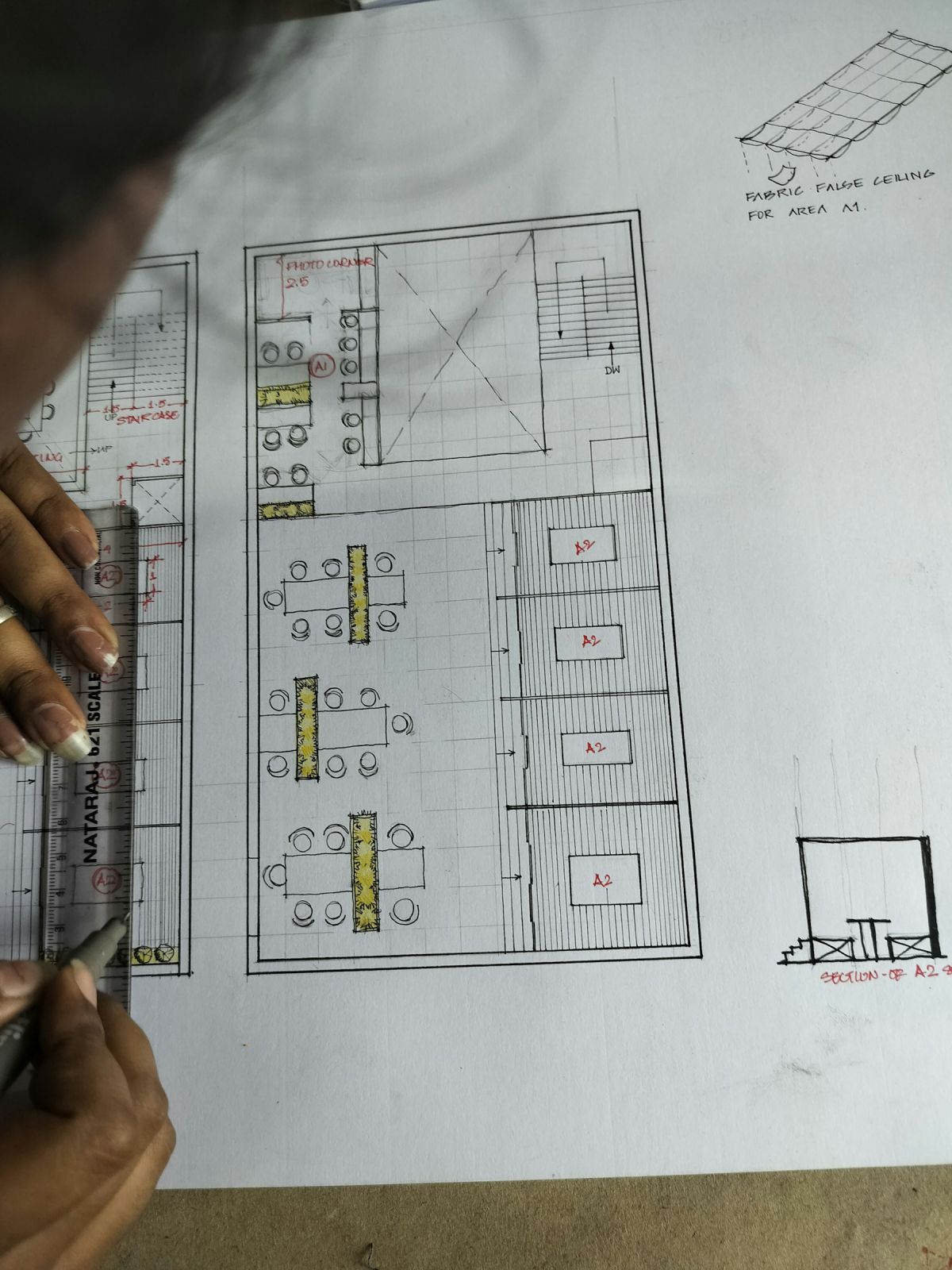 Architect marking a printed floor plan layout during design review Architect marking a printed floor plan layout during design review
