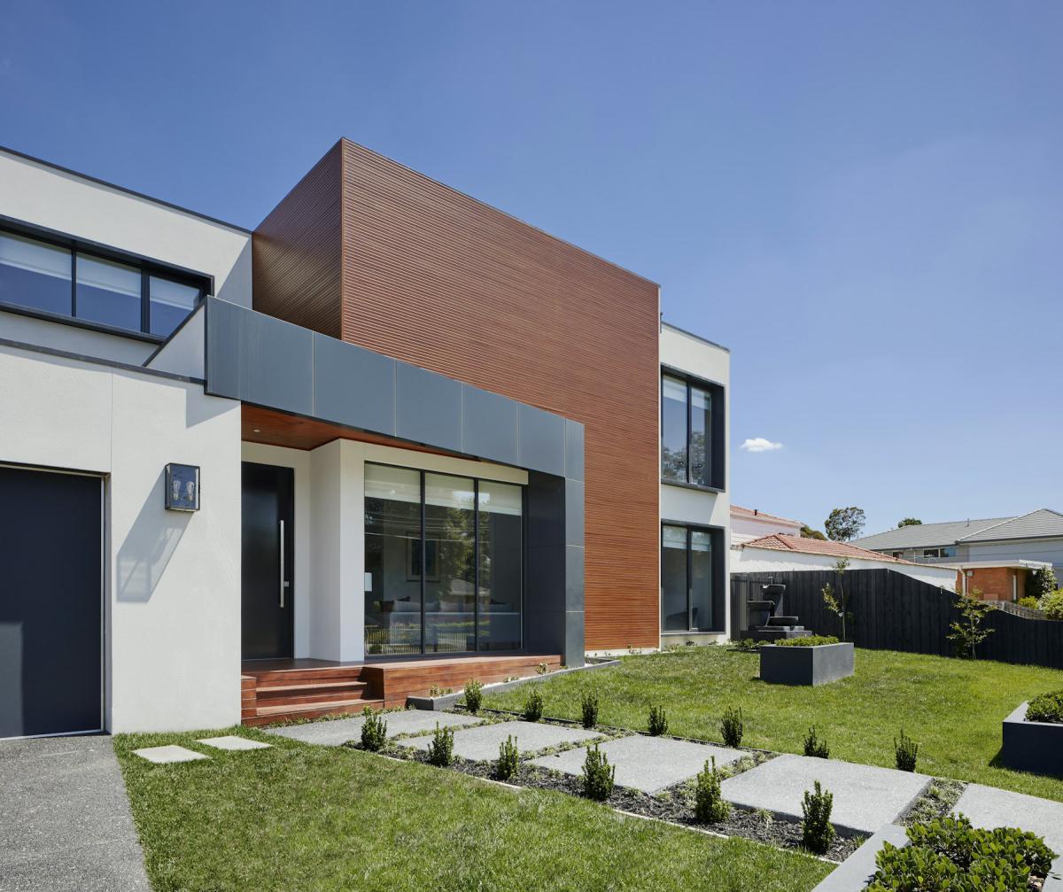 Modern house facade design combining white render, timber cladding and glass