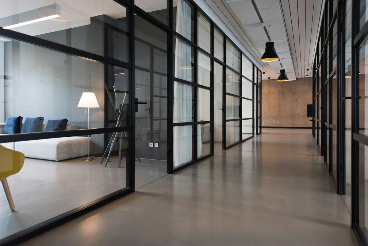 Glass-partitioned office workspace with clean corridors