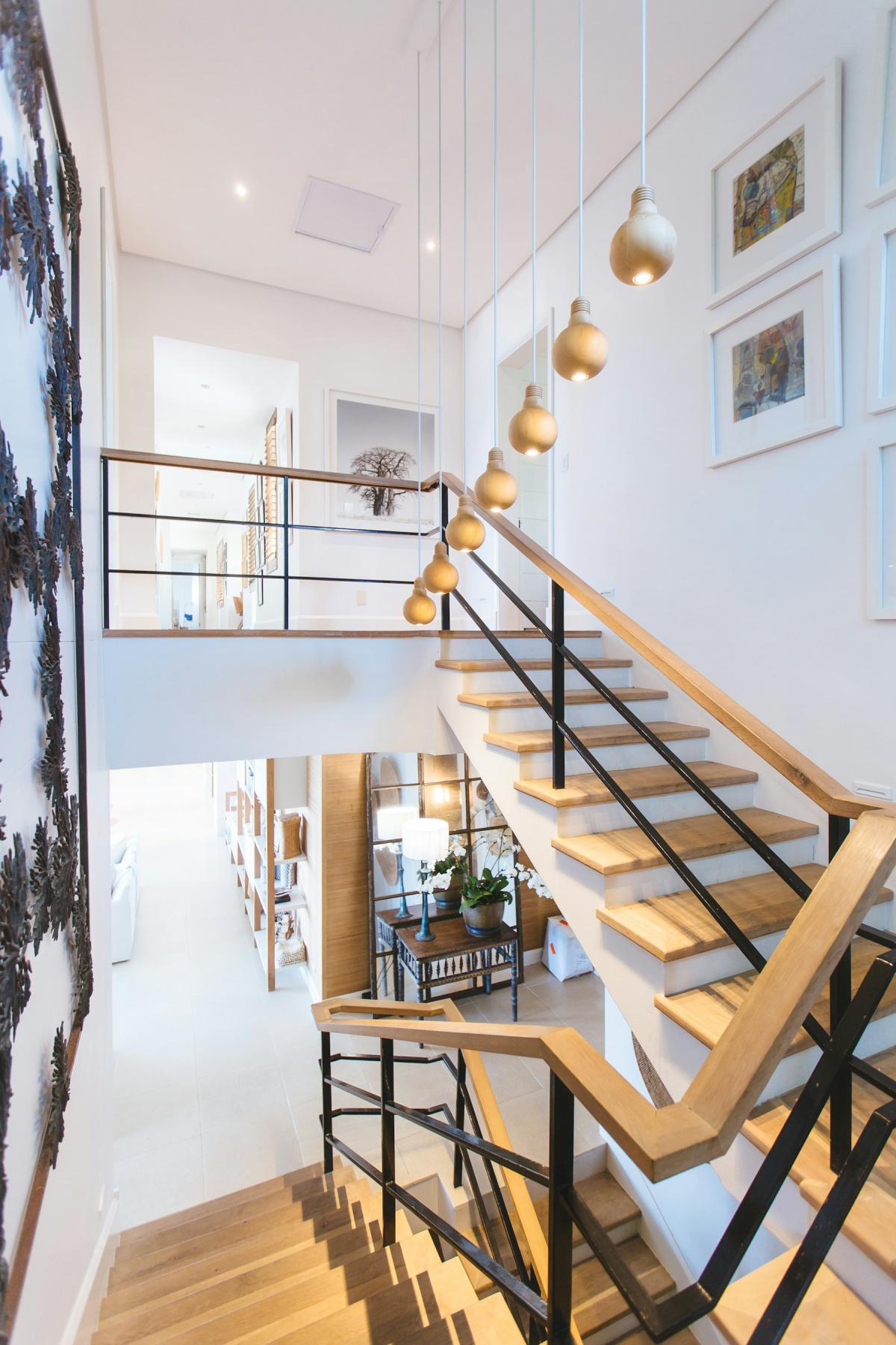 Lighting design with cascading pendant lights along a timber staircase Lighting design with cascading pendant lights along a timber staircase