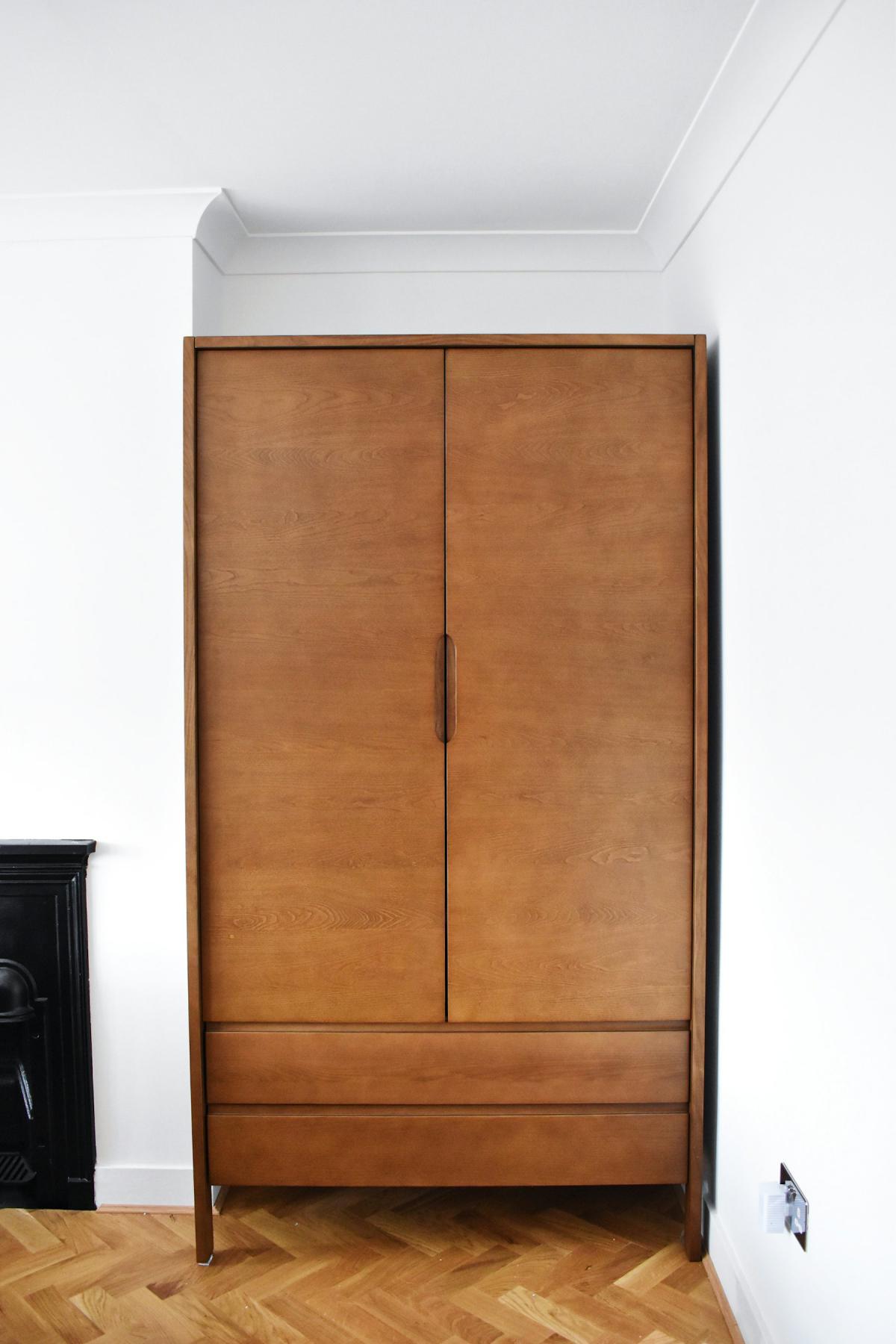 Wardrobe design in rich walnut wood veneer with full-height doors