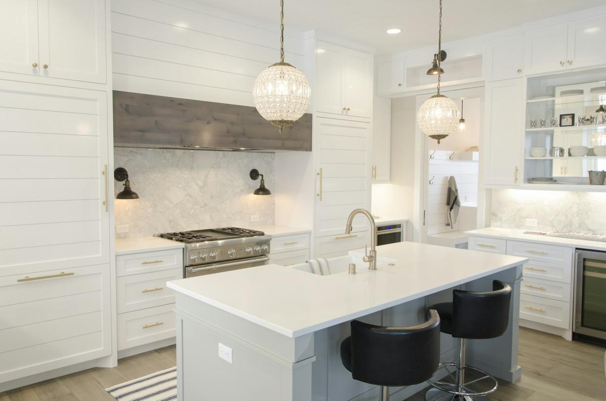 Luxury kitchen with large island, pendant lights and white cabinetry Luxury kitchen with large island, pendant lights and white cabinetry