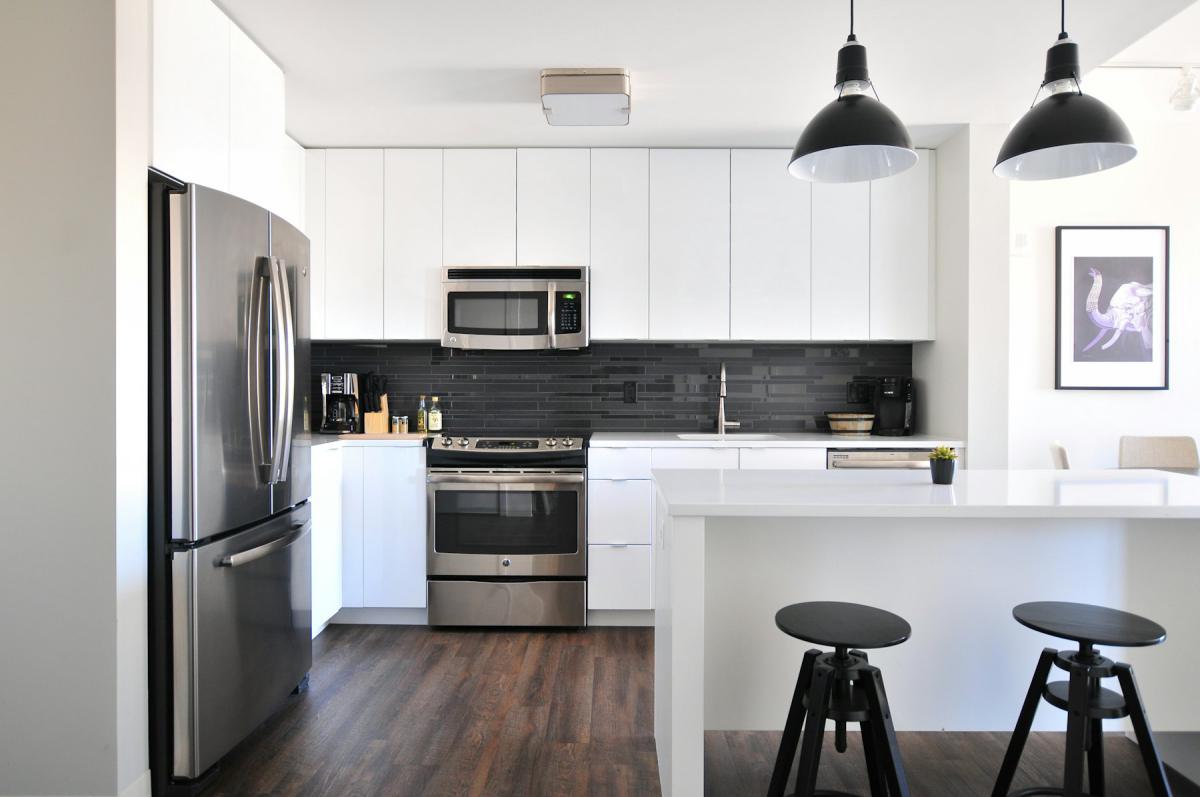 Minimal white kitchen with island seating and black pendant lights Minimal white kitchen with island seating and black pendant lights