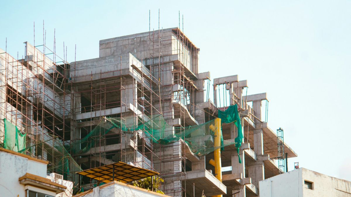Reinforced concrete villa structure under construction with safety netting Reinforced concrete villa structure under construction with safety netting