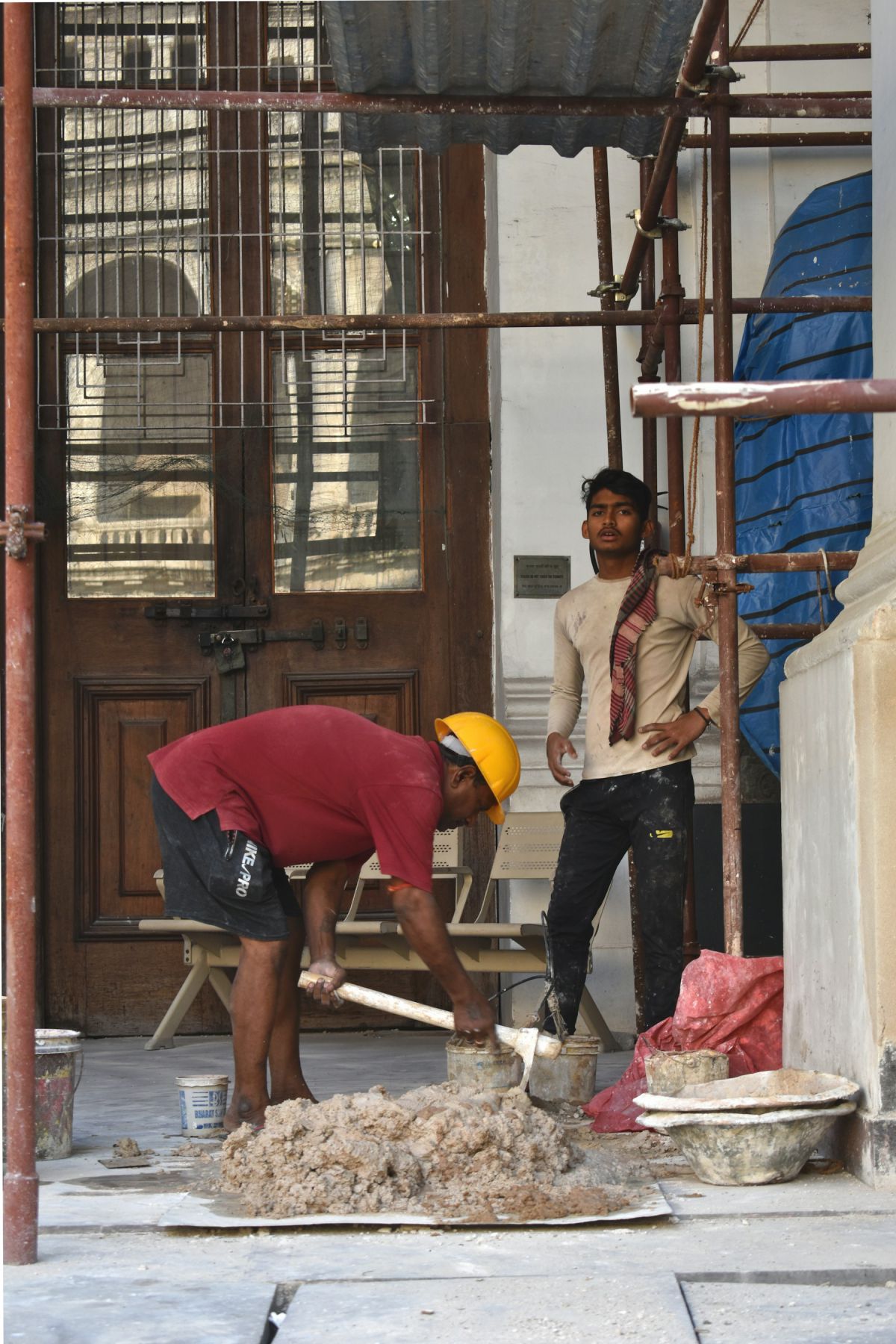 Site workers in safety helmets carrying out construction work in Hyderabad Site workers in safety helmets carrying out construction work in Hyderabad