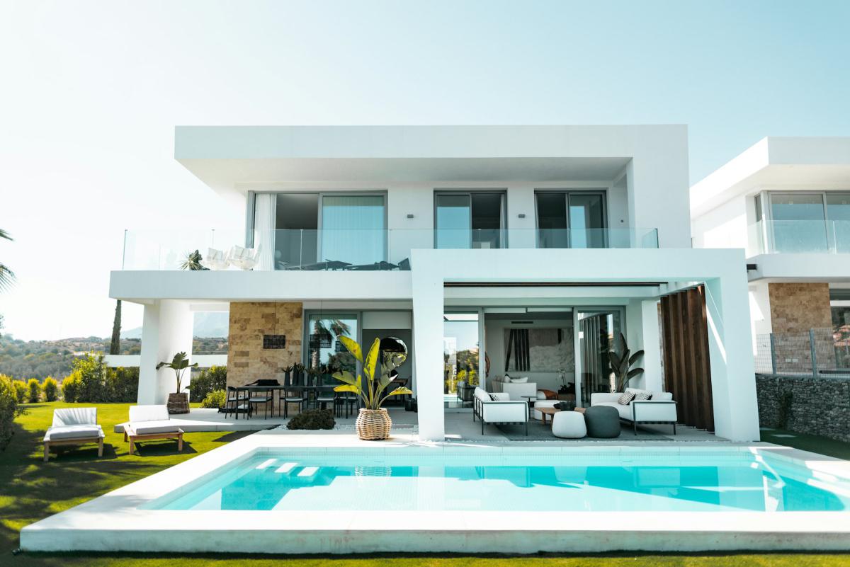 Luxury villa exterior with turquoise pool and landscaped deck