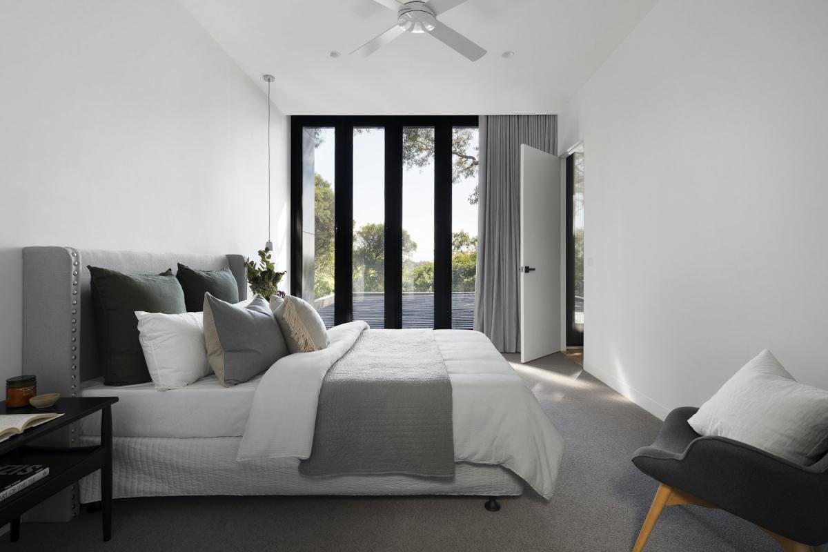 Villa bedroom interior with soft neutral palette and garden views